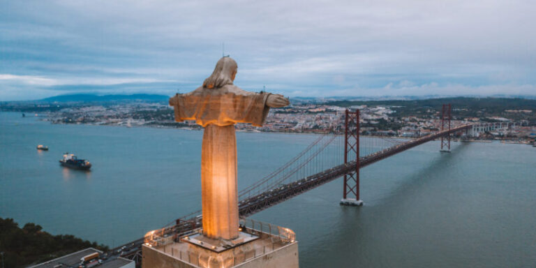 Cristo Rei Christ Statue in Lisbon in the evening time. Aerial view over Lisbon.